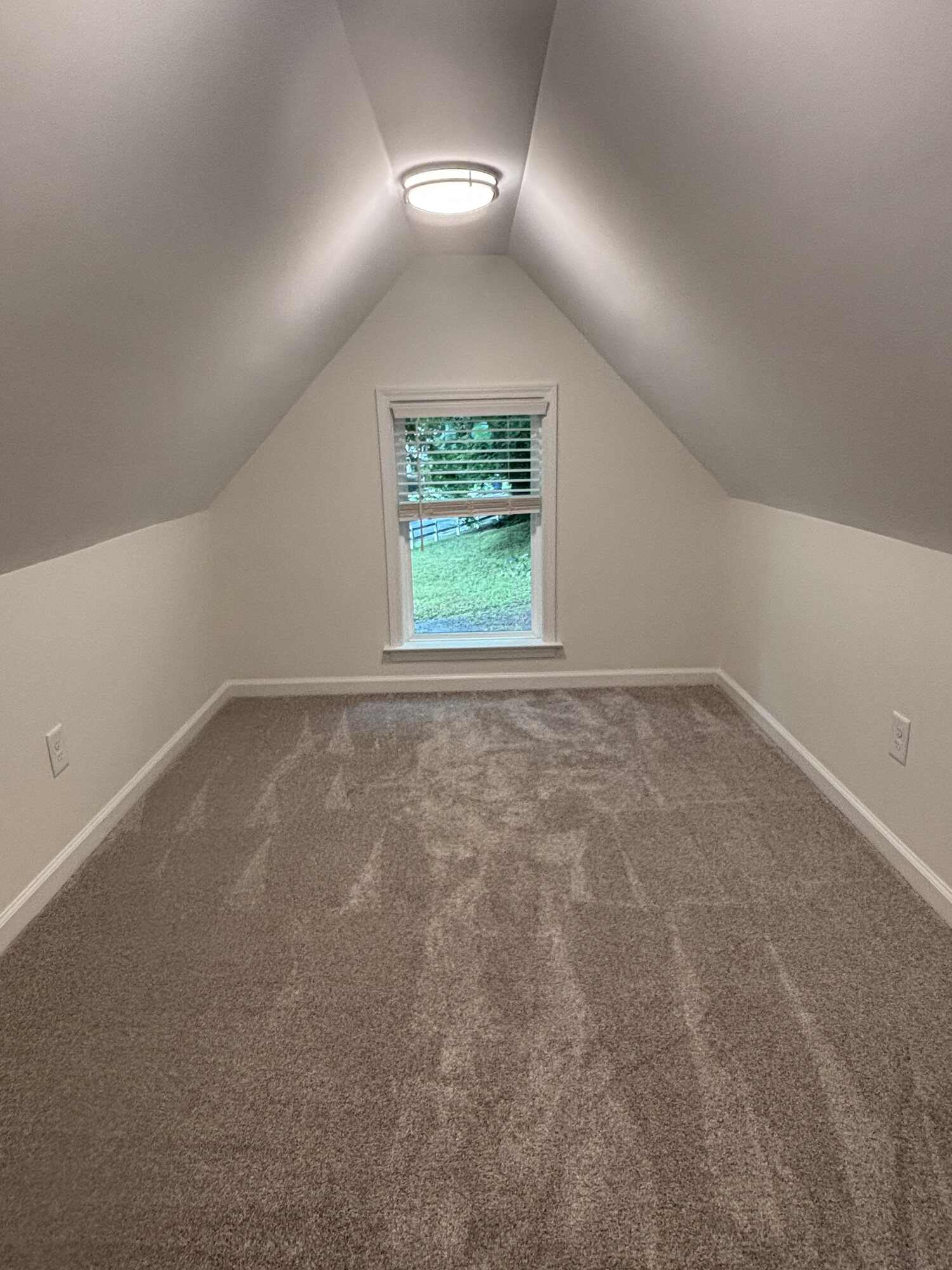The carpeted loft at the top of the ladder, under the slope of the roof