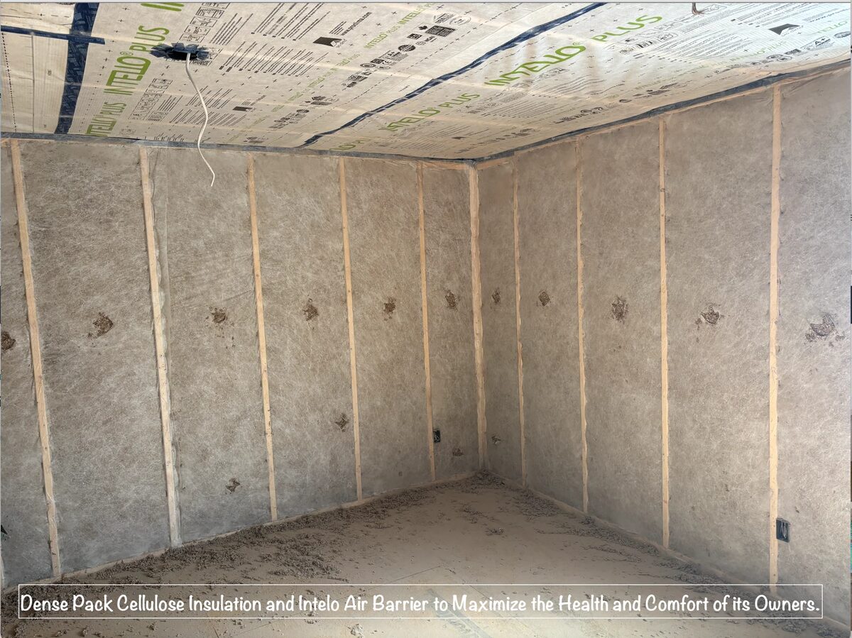 Wall cavity filled with dense packed cellulose insulation behind a taped membrane