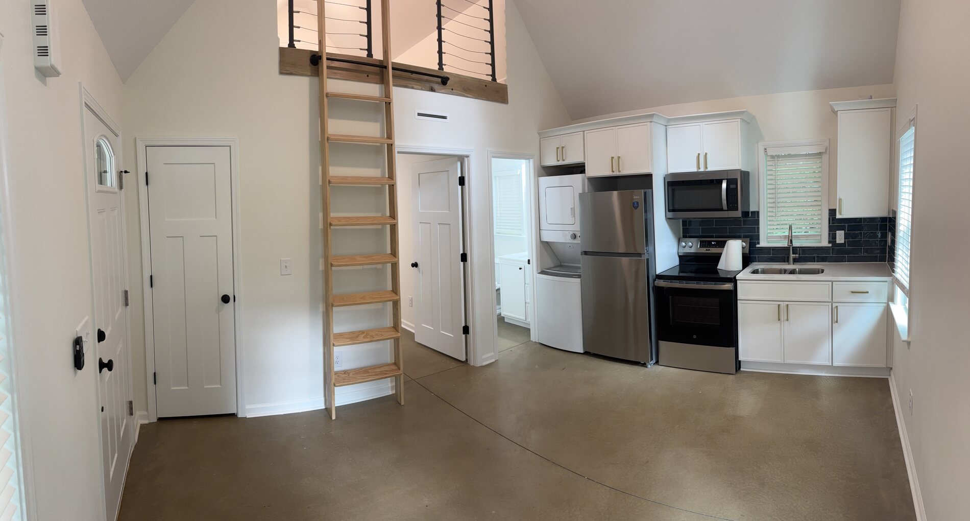 Accessory dwelling unit interior with a full kitchen and a ship ladder to the loft
